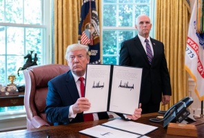 Trump displaying his signature on an executive order