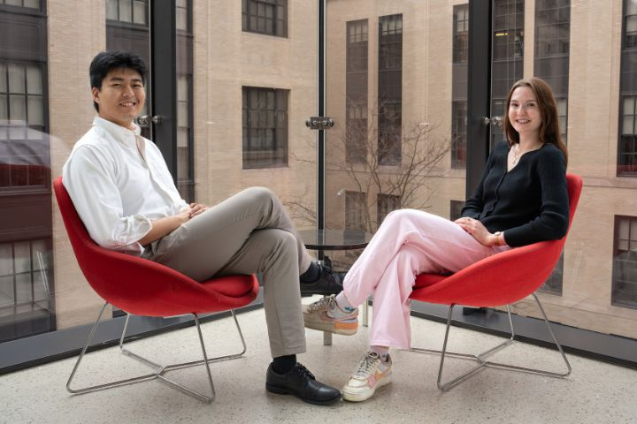 Students Kevin Guo and Erin Hovendon on red chairs