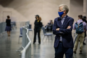 man wearing a mask watching voting